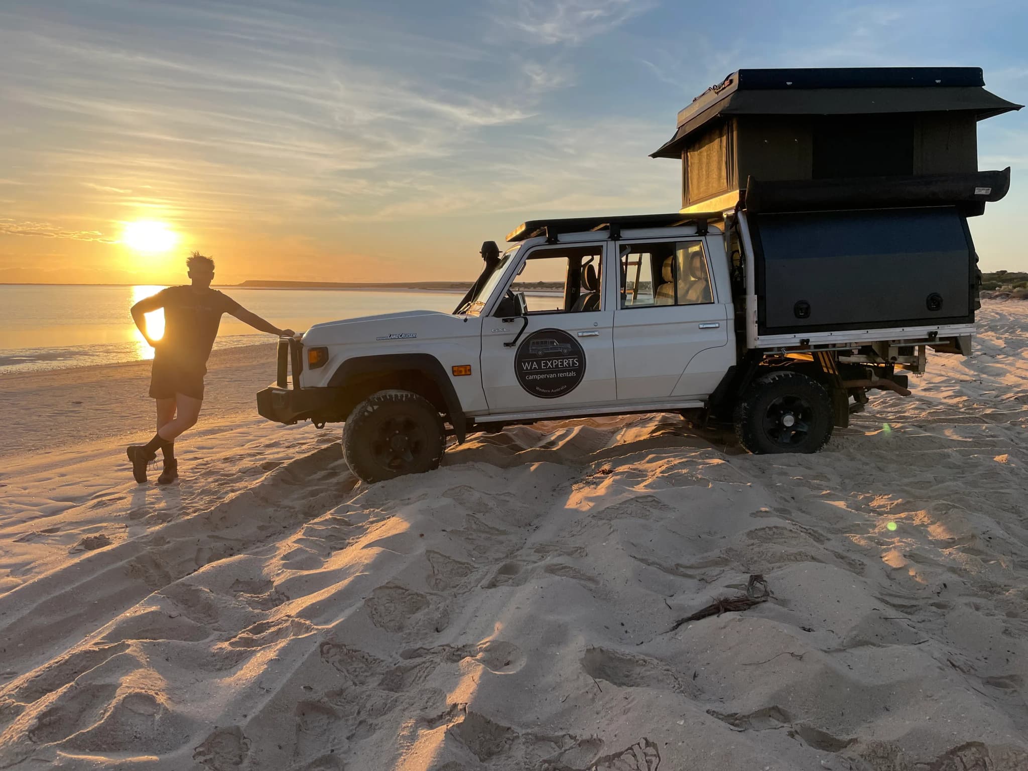 Niklas am Strand mit Allradcamper bei Sonnenaufgang