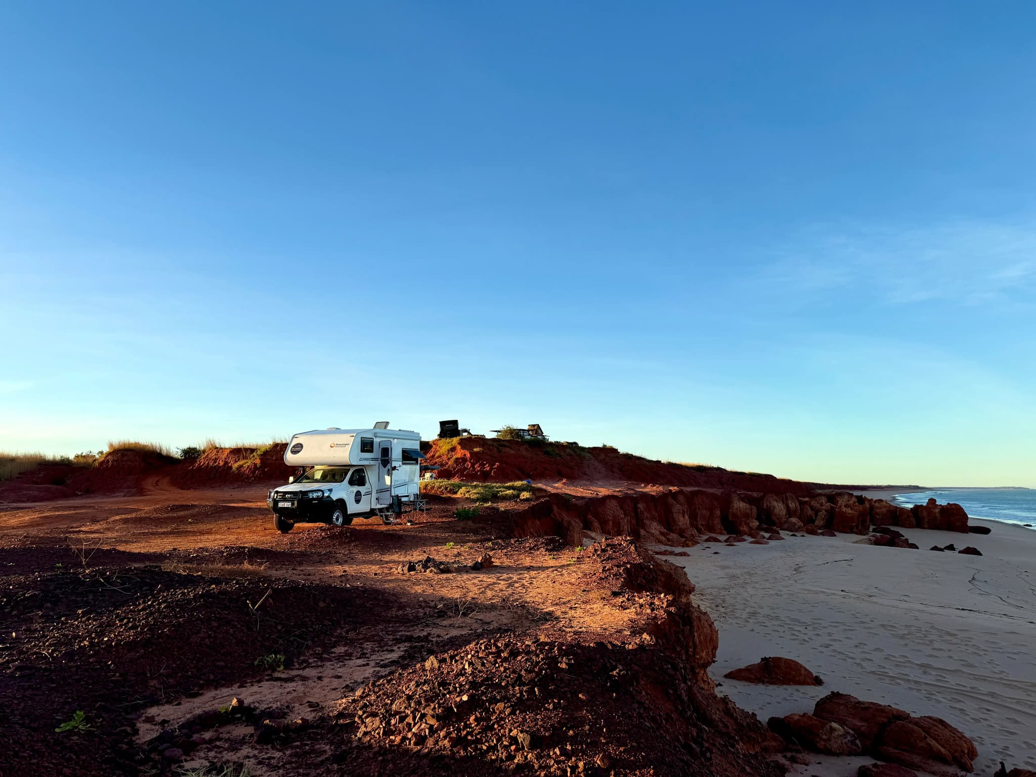 Allradcamper an eine roten Klippe im Sonnenaufgang