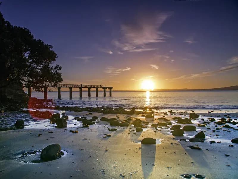 Sonnenaufgang am Strand in Neuseeland – typische Szene zur besten Reisezeit im Sommer