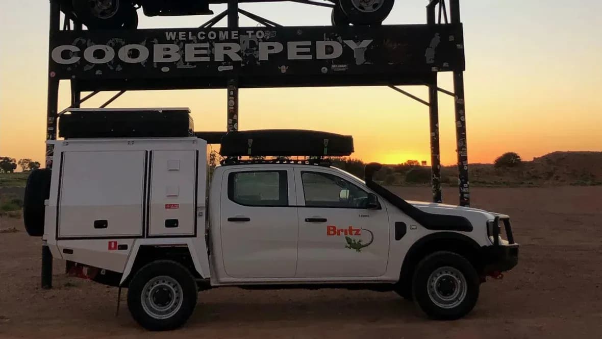 Der Warrior von Britz Rentals auf Sand geparkt bei Sonnenuntergang in Australien