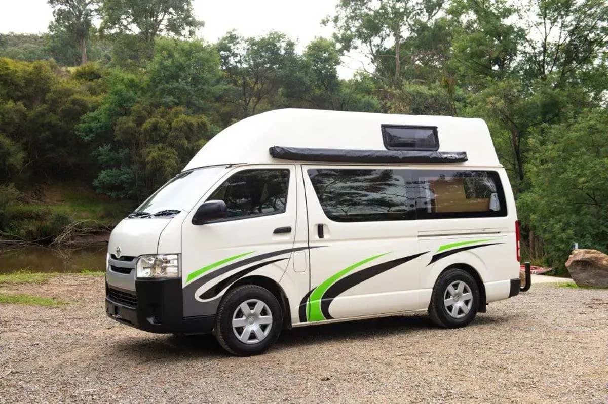 Camper stehend vor Wald