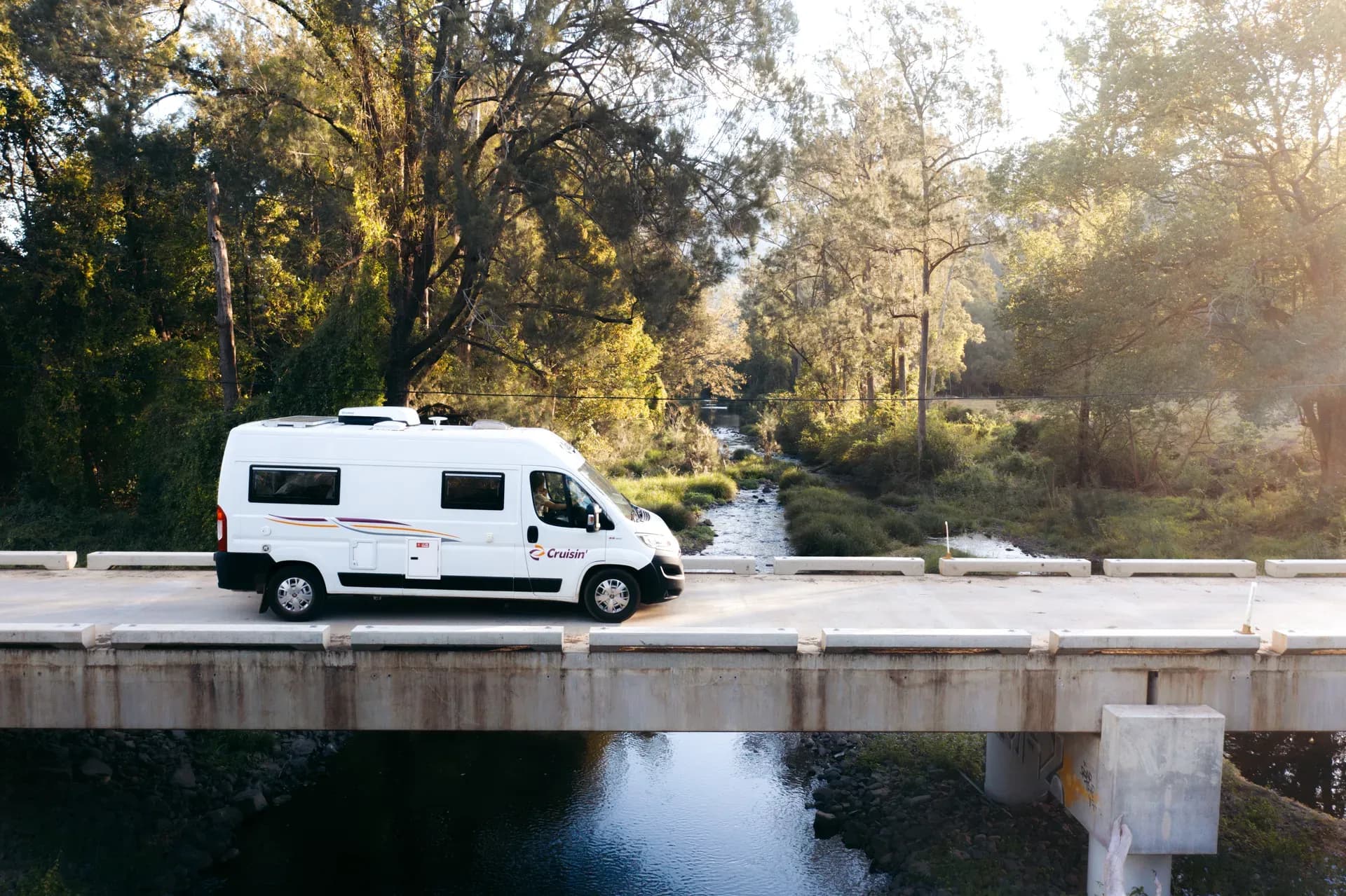 Der 2 Berth Sandpiper von Cruisin Motorhomes für 2 Personen über eine Brücke fahrend in Australien