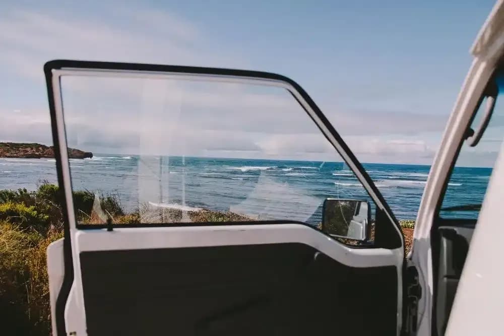 Budgie Campervan von Travellers Autobarn geparkt mit Blick aufs Meer in Australien