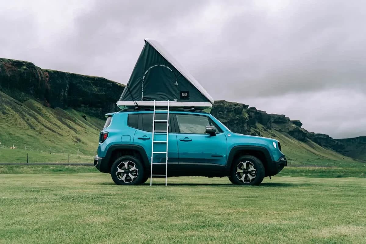 Seitenansicht des Rent.is Jeep Renegade 4xe mit aufgeklapptem Dachzelt