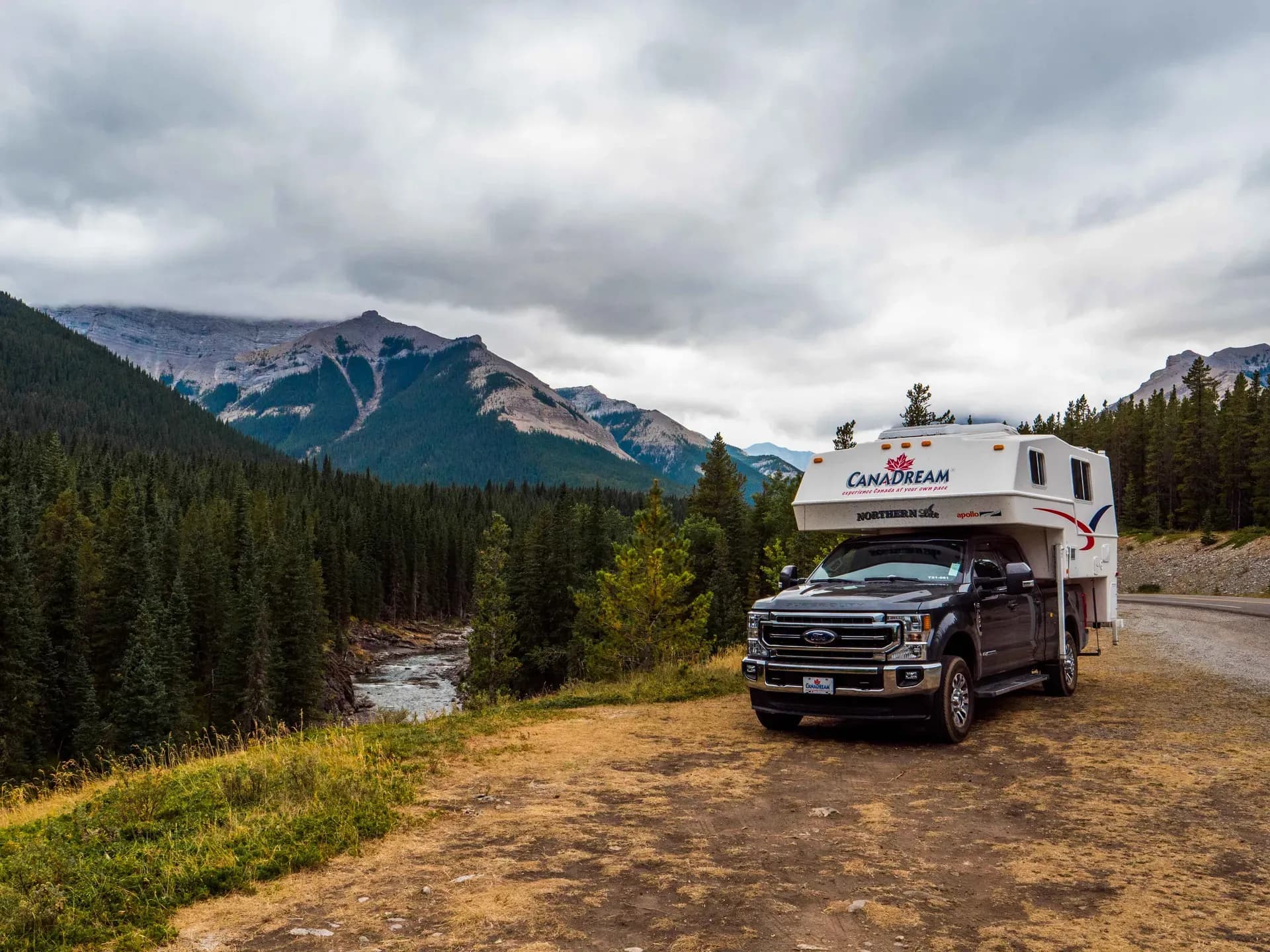 CanaDream Maxi Travel Camper in Kanada vor Berg-, Fluss- und Waldkulisse