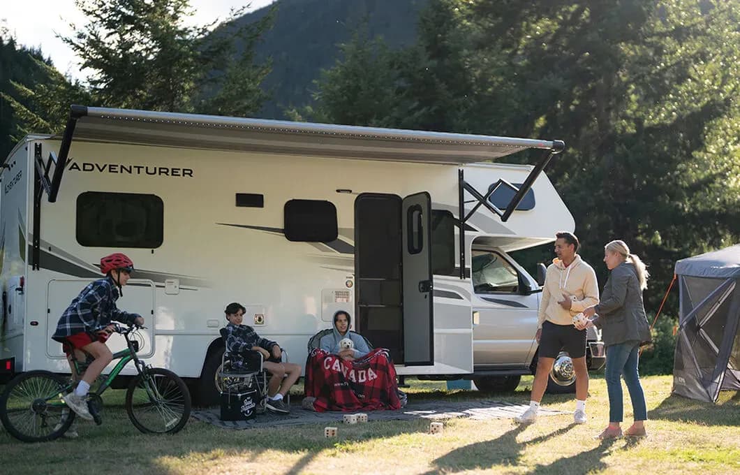 Der Class C Motorhome-Large von Fraserway RV geparkt auf einer Wiese mit einer Familie in Kanada