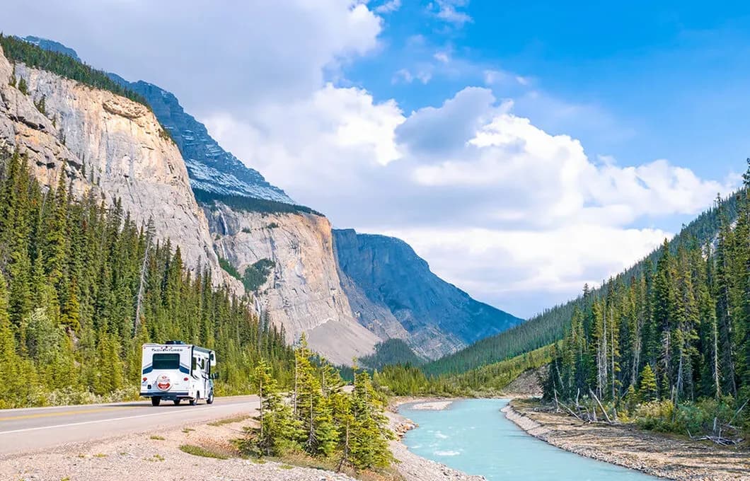 Class C Motorhome-Small von Fraserway RV fahrend durch Berge neben einem Fluss in Kanada