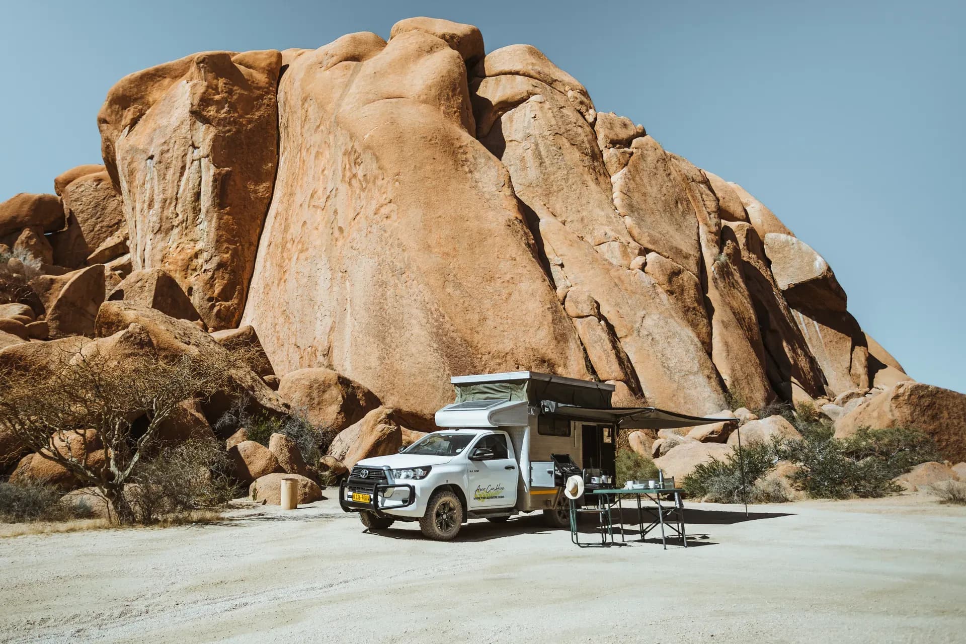 Budget VKK Hilux SC Bushcamper von Asco Car Hire in Namibia vor Felsformation