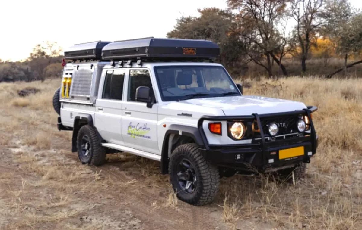 Der Premium Q Landcruiser DC 2.8TD von Asco Car Hire in trockener Landschaft in Namibia