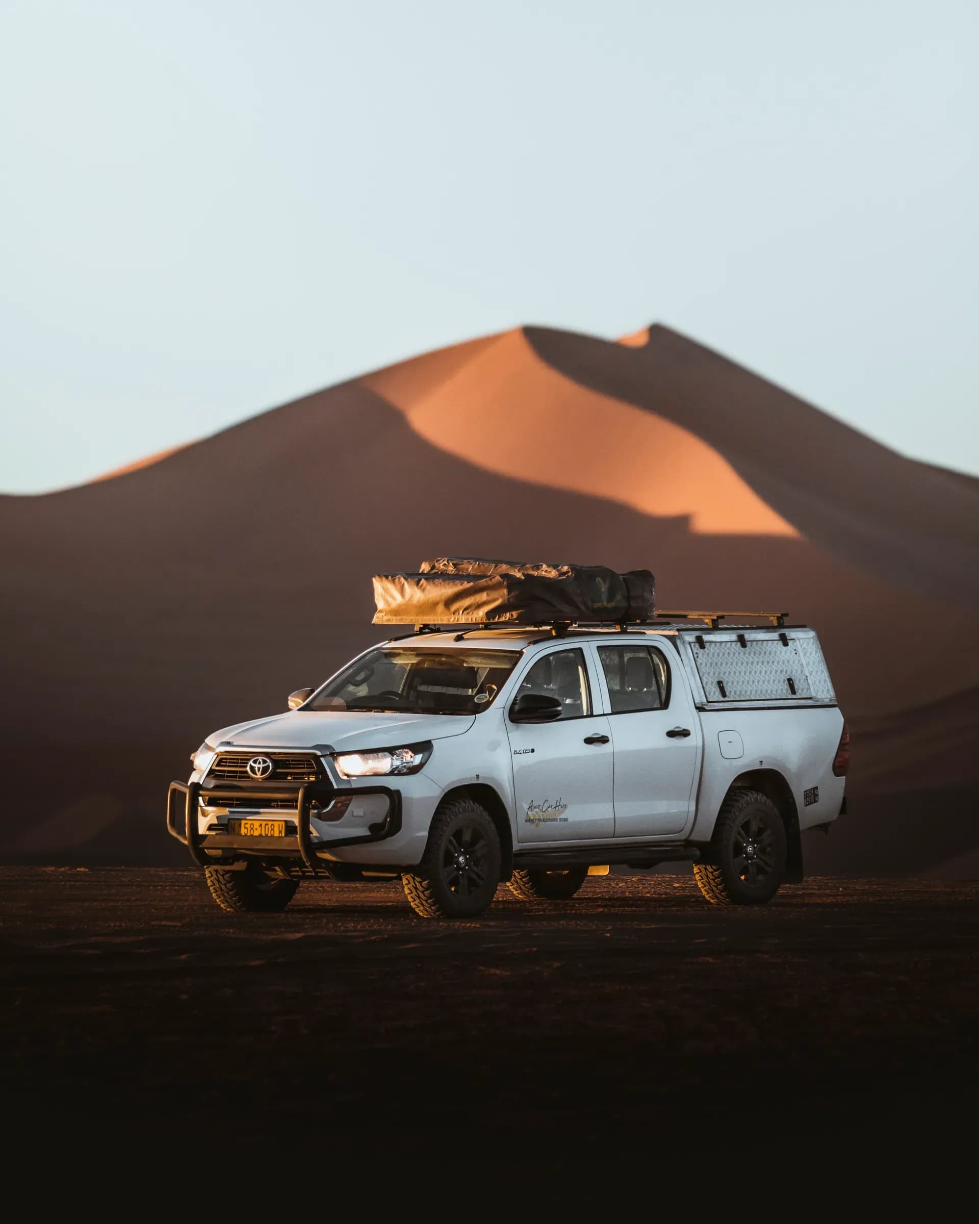 Der Premium S Hilux DC 2.4TD von Asco Car Hire vor einer Sanddüne