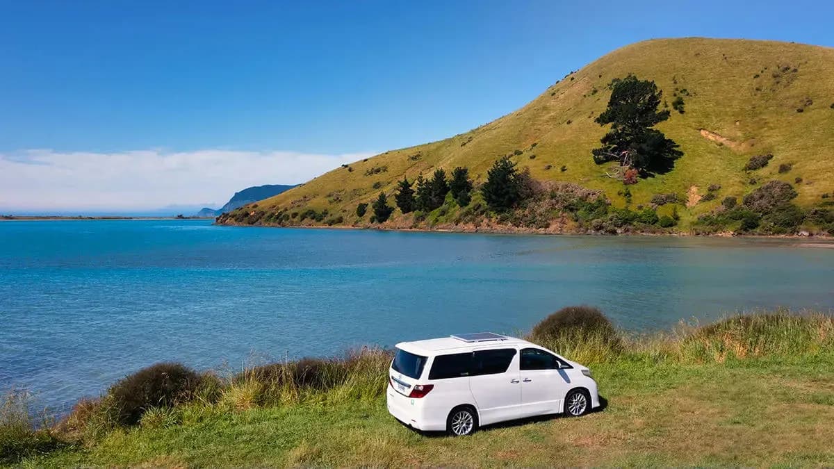 Der 2 Berth Sleepavanz von Discover NZ Motorhome Rentals an der Küste in Neuseeland