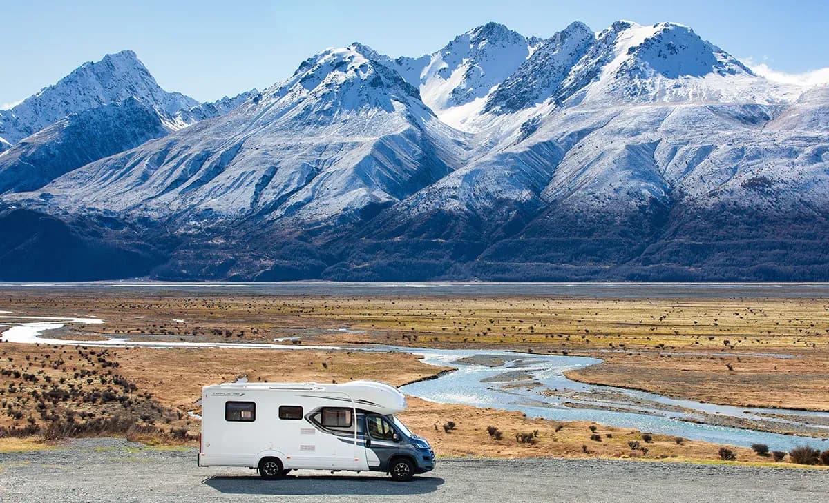 Camper auf Wieseo vor einem See