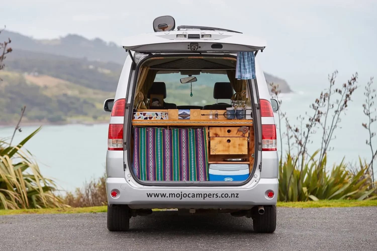 Der Sleepervan Generation 1 von Mojo Campers vor dem Meer in Neuseeland