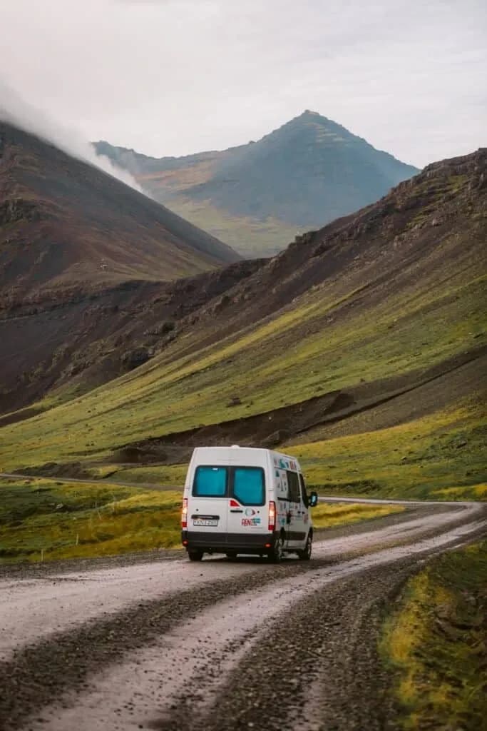 Rent.is Renault Master 5 auf einer Straße durch ein grünes Tal