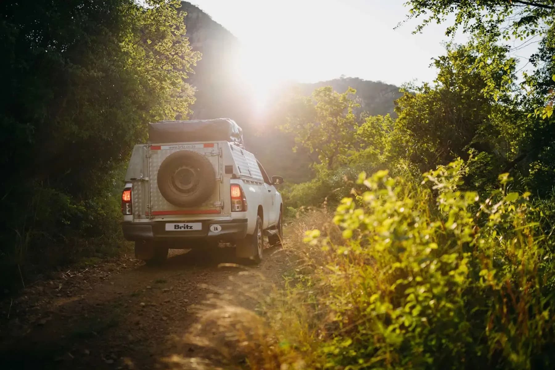 suedafrika, britz rentals, budget hilux soft shell 2 pax, heckansicht bei sonnenaufgang