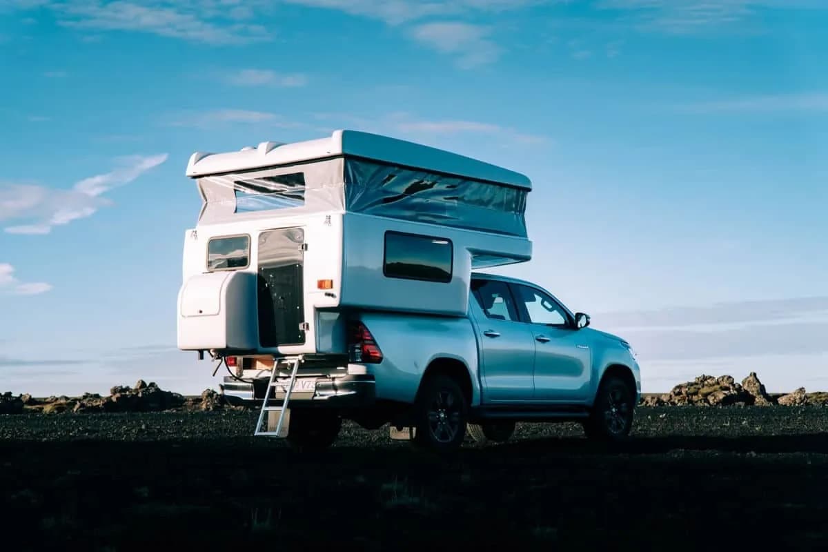 Rent.is Toyota Hilux mit geöffneter Kabinentür und Leiter