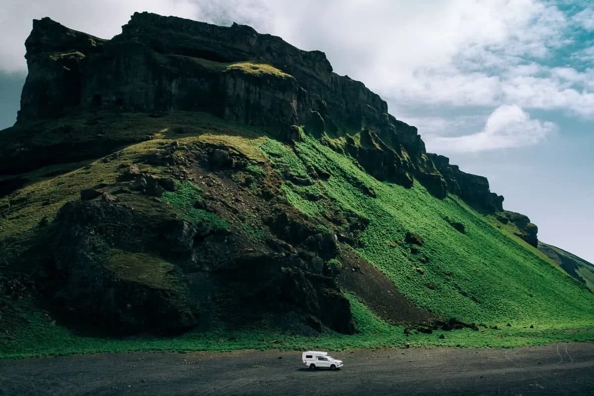 Rent.is Toyota Hilux 4x4 Camper vor einem moosbewachsenen Berg