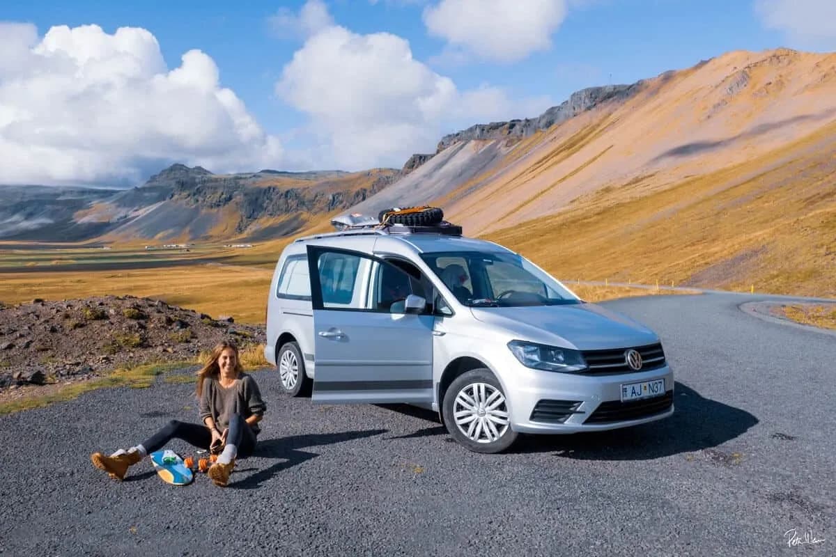 Frau sitzt vor dem Rent.is VW Caddy Camper Automatik