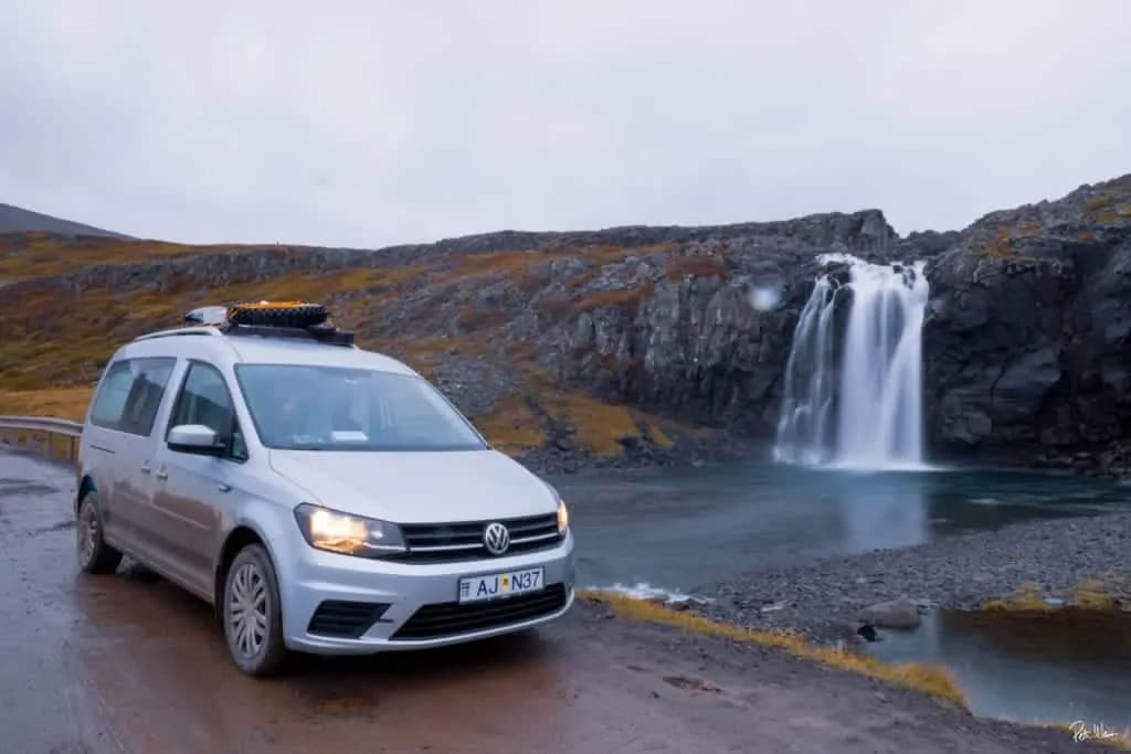 Rent.is VW Caddy Camper vor einem Wasserfall