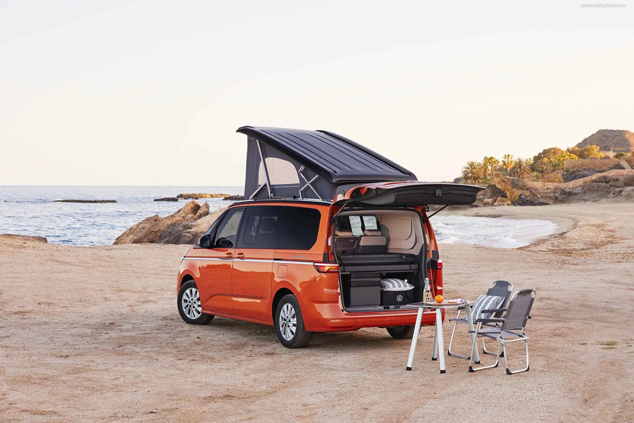 Rent.is VW California Beach 2026 Hybrid mit Aufstelldach und Campingstühlen am Strand