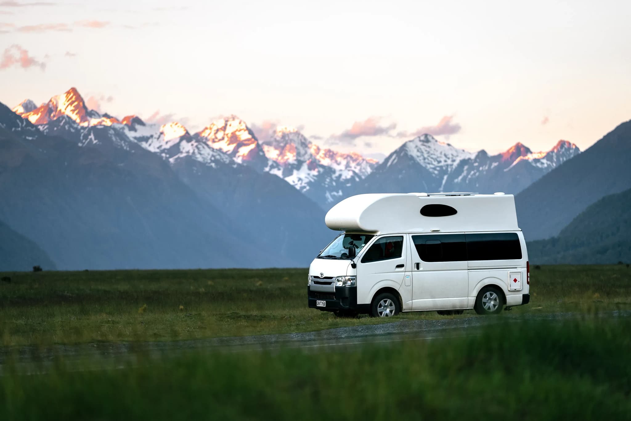 Camper in Neuseeland vor den Bergen mit Schnee