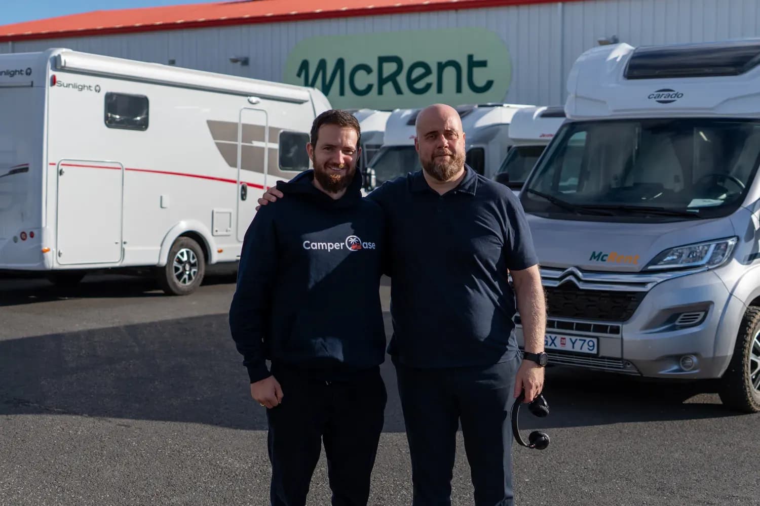 Vertreter von CamperOase und McRent zwischen Wohnmobilen vor der McRent-Mietstation in Island.