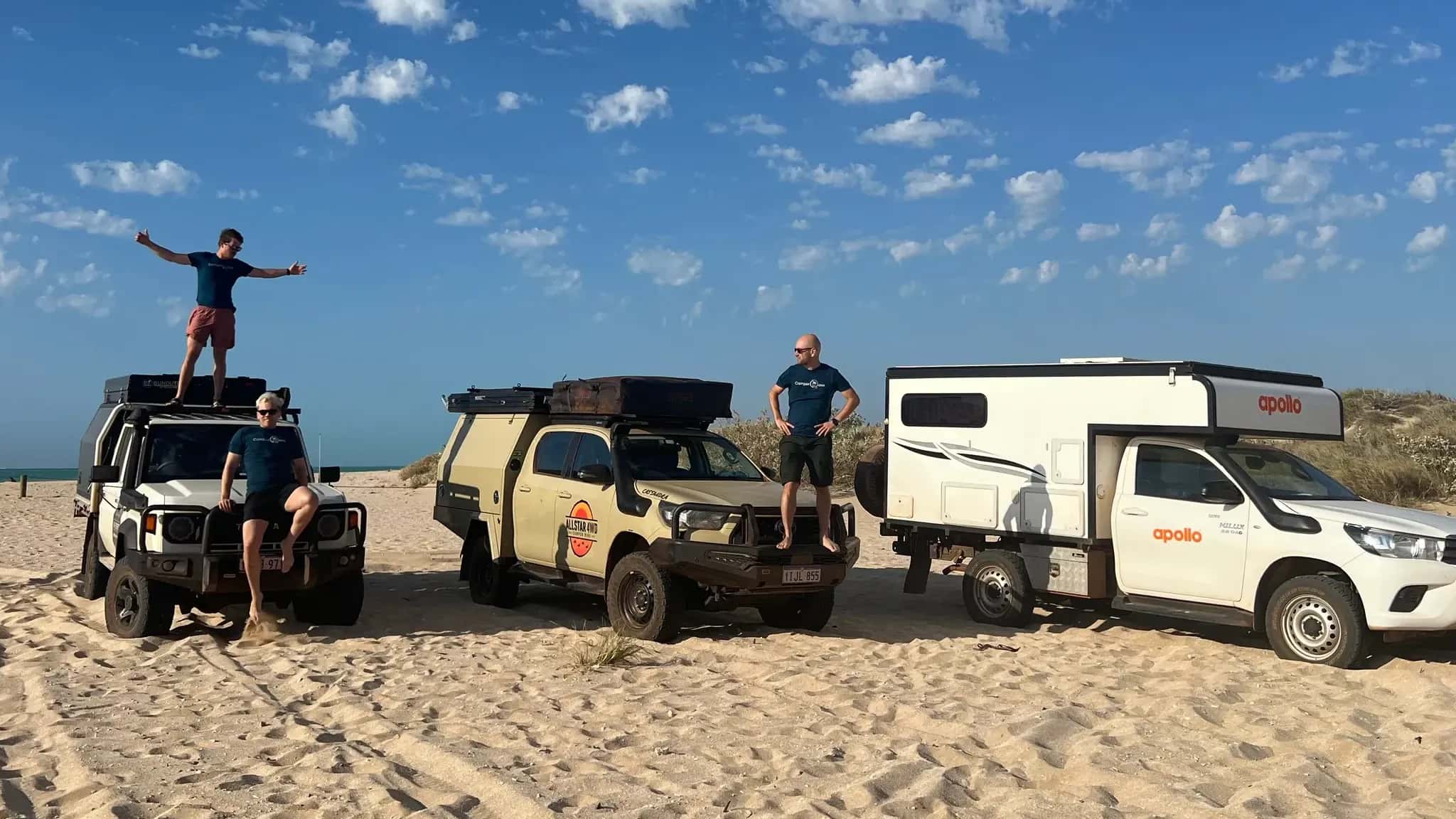 Mitarbeiter der CamperOase auf Fahrzeugen am Strand in Australien